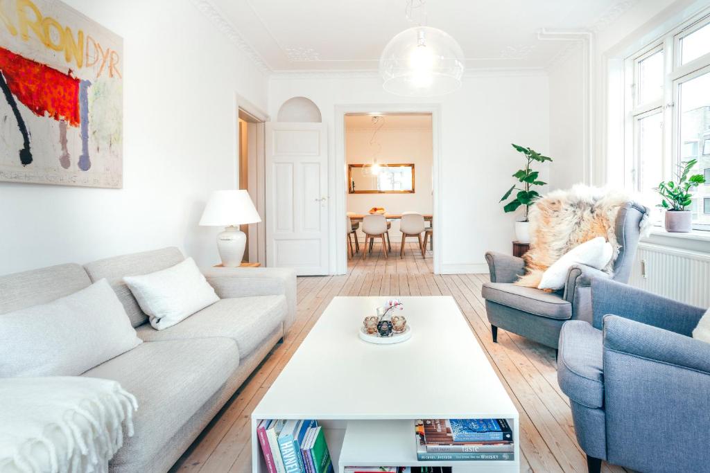 uma sala de estar com um sofá e uma mesa em Elegant, evocative and cosy home in Østerbro with a panoramic view. Eco-friendly. 1km harbour/ beach, 3km- city center, 13km-airport. em Copenhague