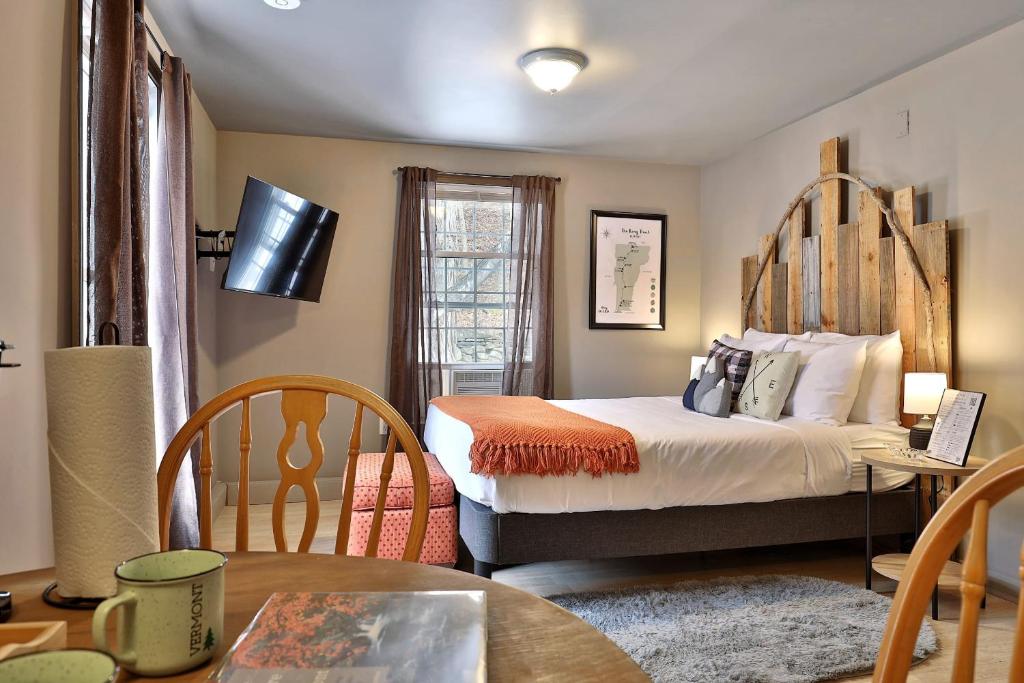 1 dormitorio con 1 cama, mesa y sillas en Long Trail Suite at The Bridgewater Inn, en Bridgewater