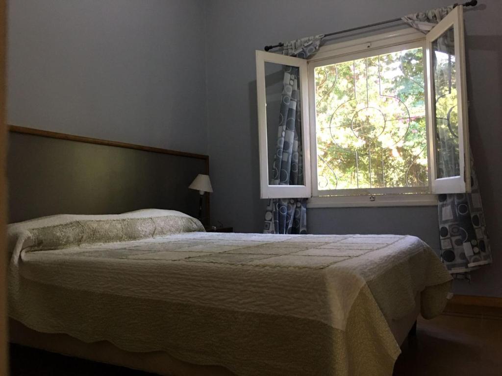 1 dormitorio con cama y ventana en CASA - CHALET VILLA DEL DIQUE en Villa del Dique