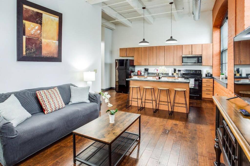 a living room with a couch and a kitchen at Centric NY Style Loft w/King bed in Rochester