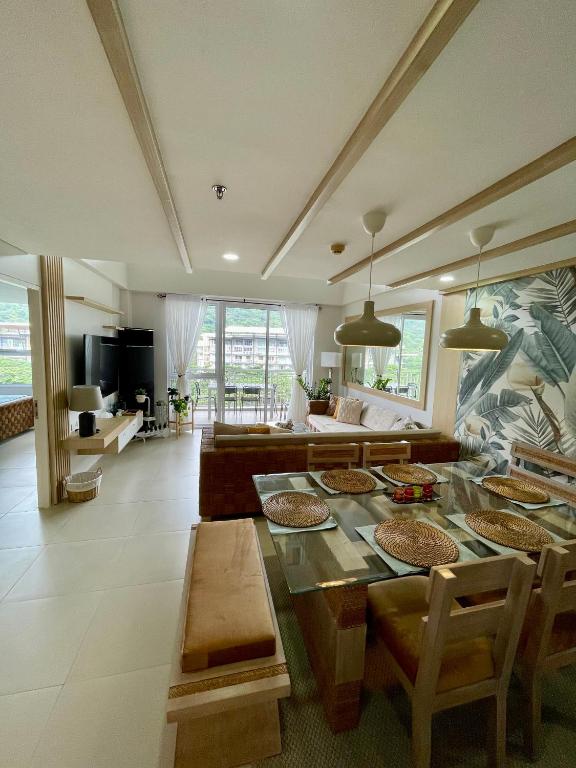 a living room with a table and a couch at 3BD/3BA Penthouse - Tropical Oasis in Pico de Loro in Patungan