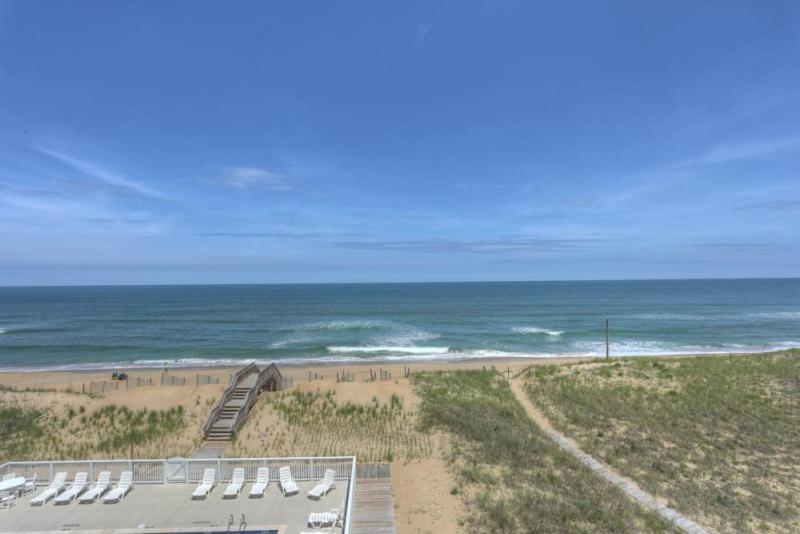 a view of a beach with chairs and the ocean at TSC404 Seaclusion Oceanfront Elevator in Kill Devil Hills