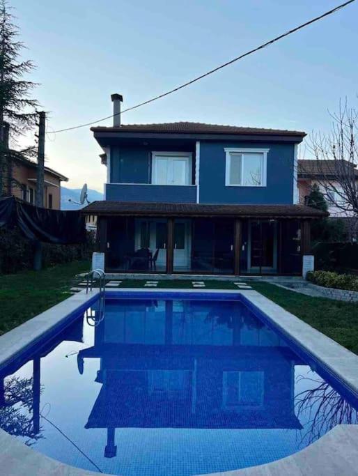 una casa azul con piscina frente a una casa en Mek Villa, en Sapanca