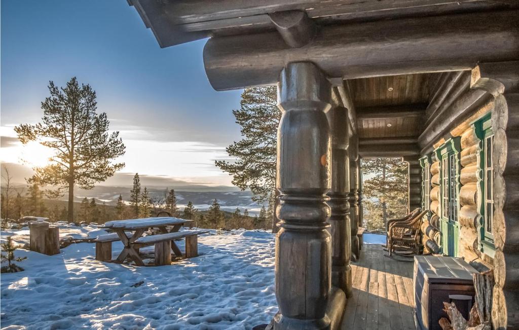 eine Blockhütte im Schnee mit einem Picknicktisch in der Unterkunft 4 Bedroom Stunning Home In Rendalen in Rendalen
