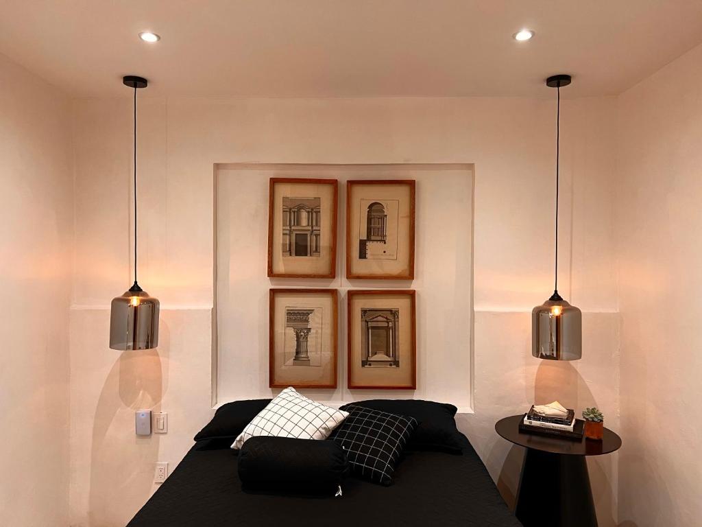 a bedroom with two pendant lights and a bed at Hotel Atia in Guadalajara