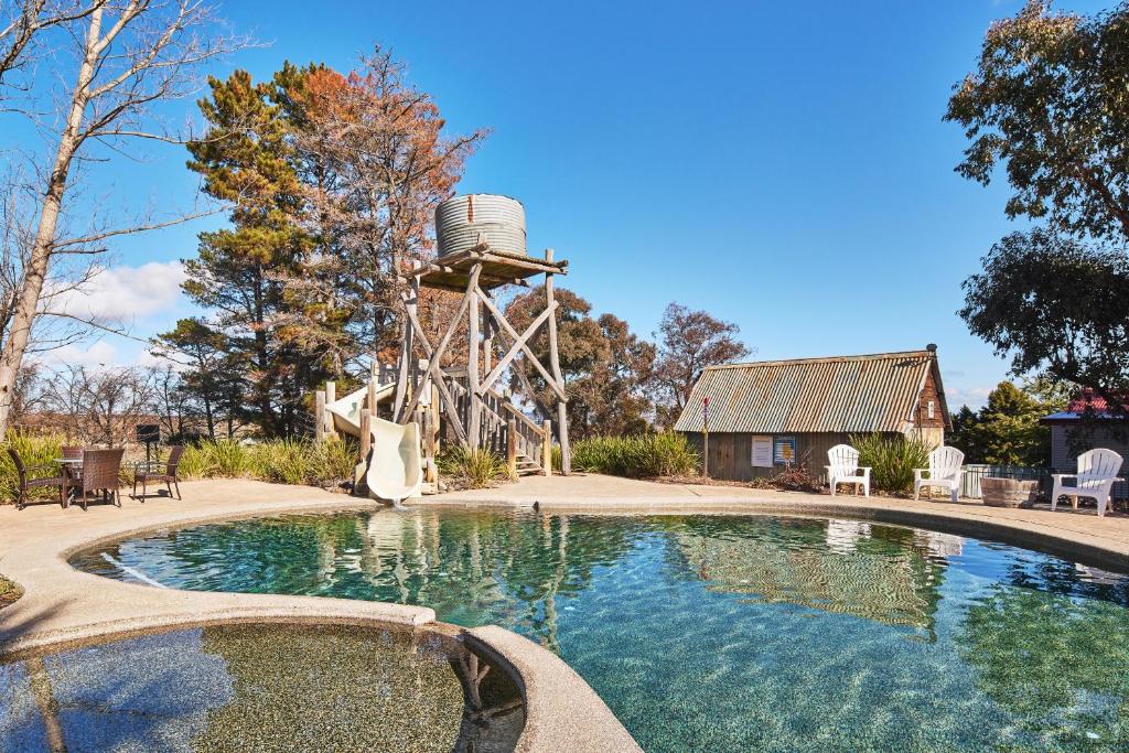 - une piscine avec un toboggan et un moulin à eau dans l'établissement NRMA Bathurst Panorama Holiday Park, à Bathurst