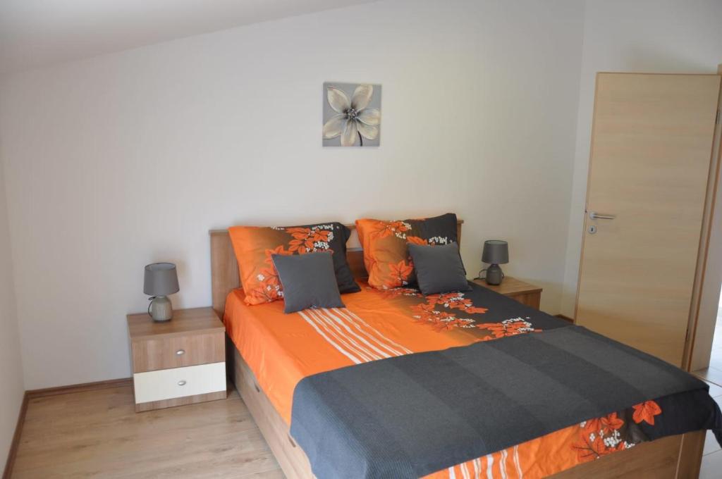 een slaapkamer met een bed met een oranje deken bij Apartment Doni in Split