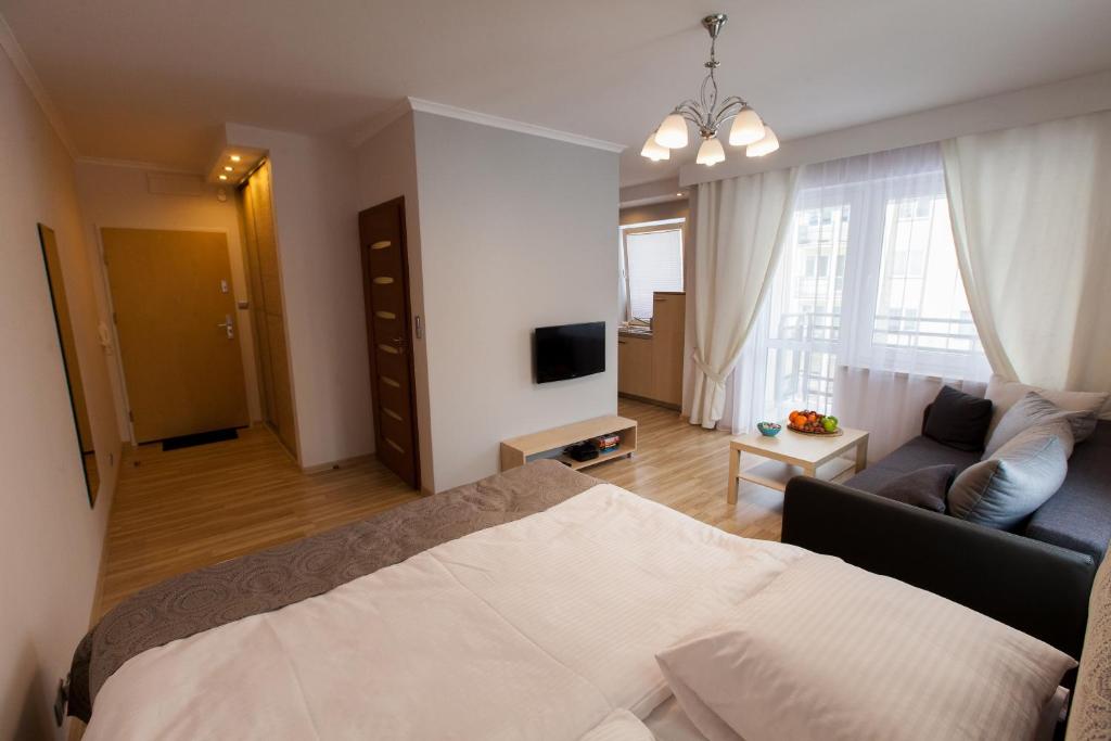 een slaapkamer met een bed en een woonkamer bij Apartament Klonowa in Kielce