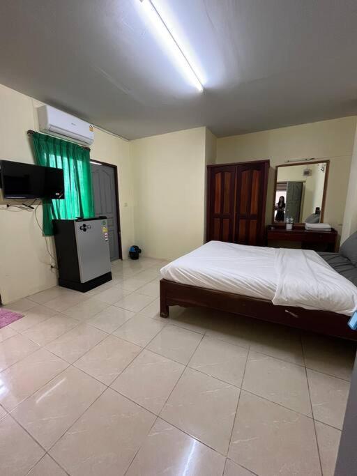 a bedroom with a bed and a television in it at Rooftop room in We Residence in Pattaya