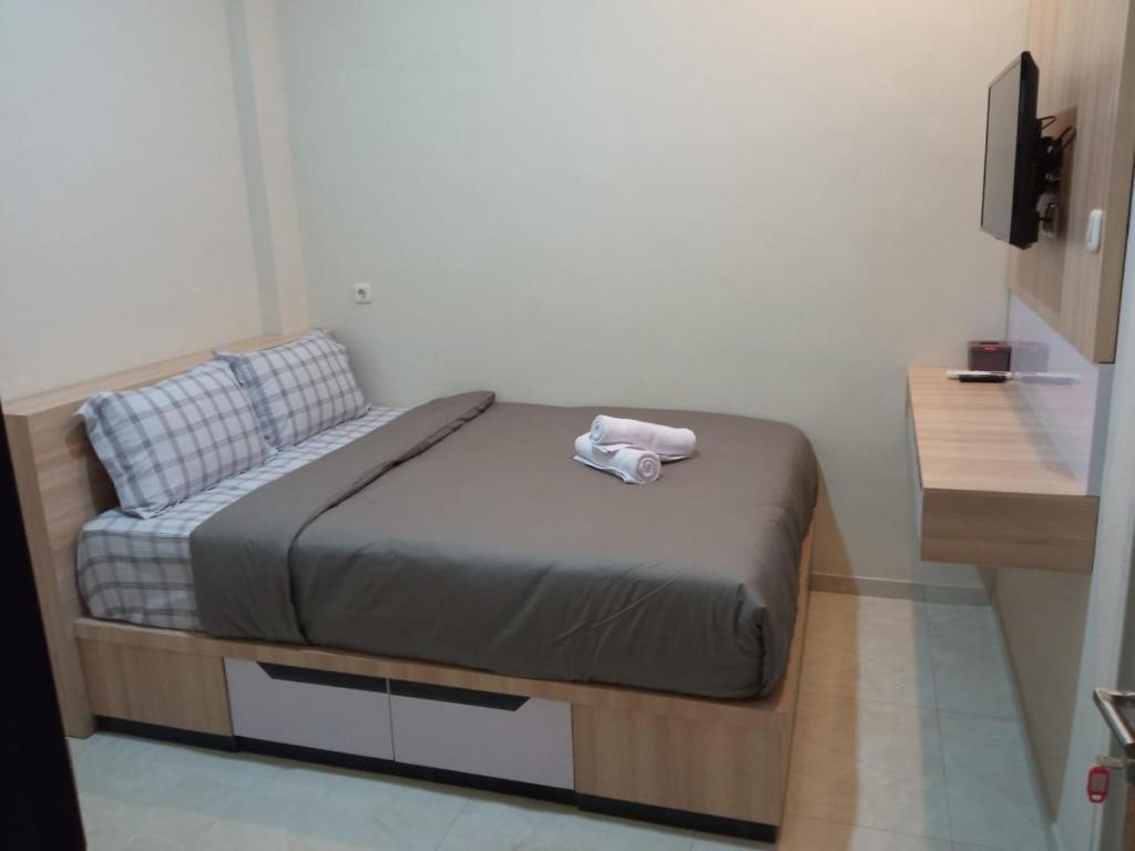 Un pequeño dormitorio con una cama con una toalla. en Shofa boarding house syariah, en Jenggrik