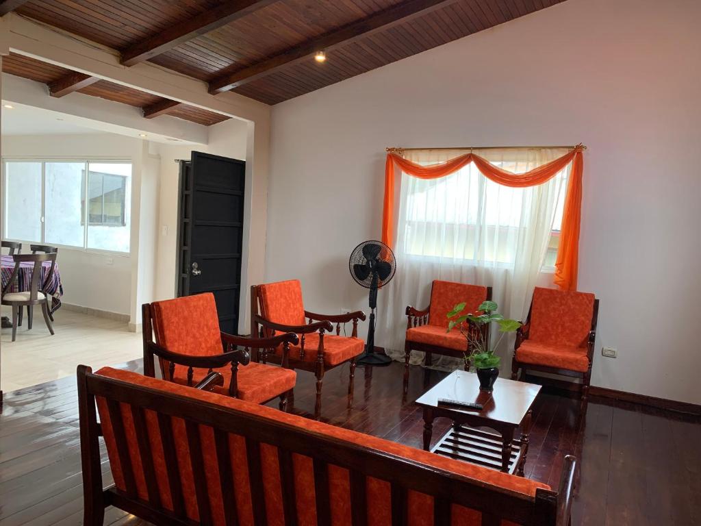 una sala de espera con sillas naranjas y una mesa en MY HOUSE IN MACAS, MIRADOR AL UPANO, en Macas