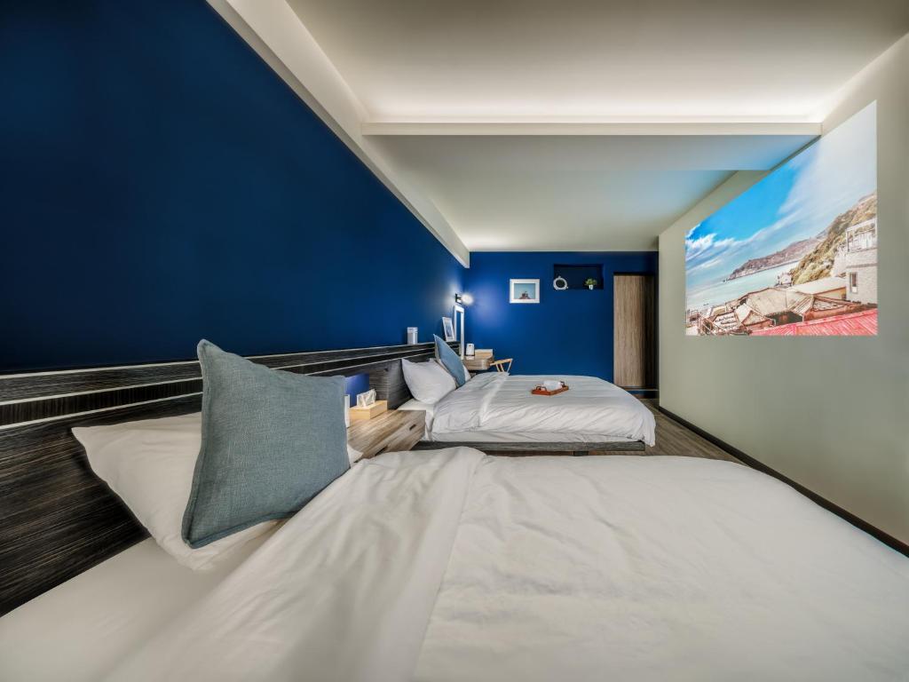 a bedroom with a large bed and a blue wall at 小島上island in Dongyin