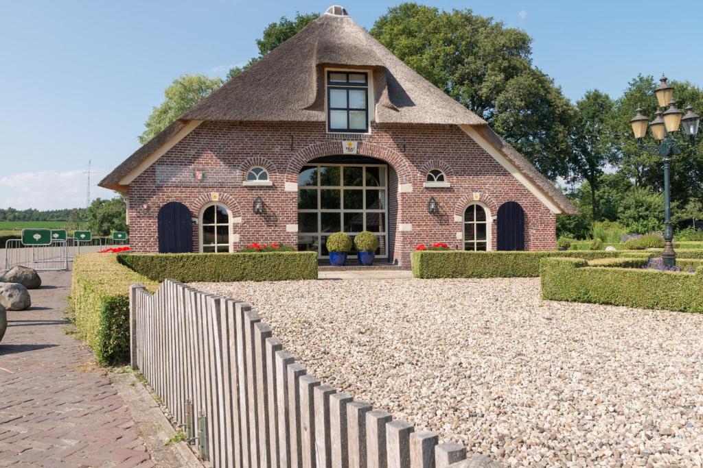 a small brick building with a fence in front of it at Herberg de Kemper in Markelo