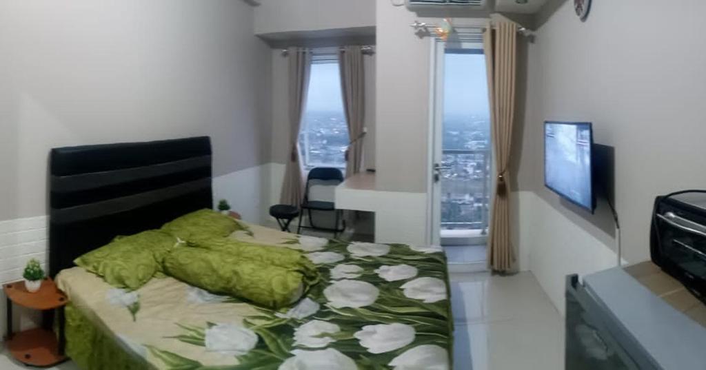 1 dormitorio con 1 cama con edredón verde en Adits en Karawang