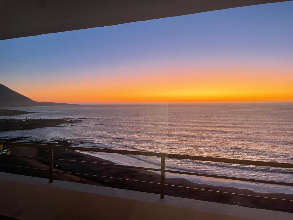 d'un balcon offrant une vue sur l'océan au coucher du soleil. dans l'établissement Departamento con vista al mar, à Iquique