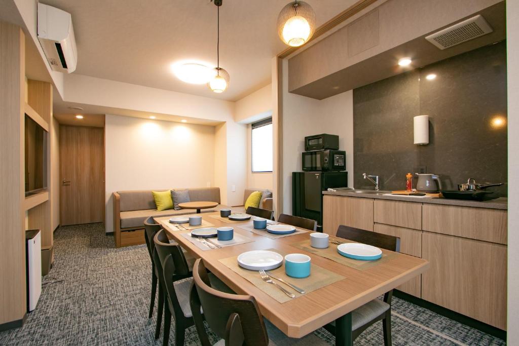 Zimmer mit einem Tisch mit Stühlen und einer Küche in der Unterkunft Minn Kappabashi in Tokio