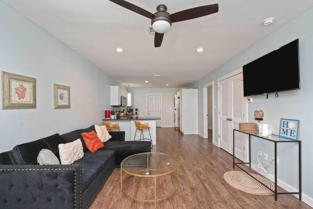 ein Wohnzimmer mit einem schwarzen Sofa und einem Flachbild-TV in der Unterkunft Stylish 2 bedroom home close 2 dtown, nas, and bch in Pensacola