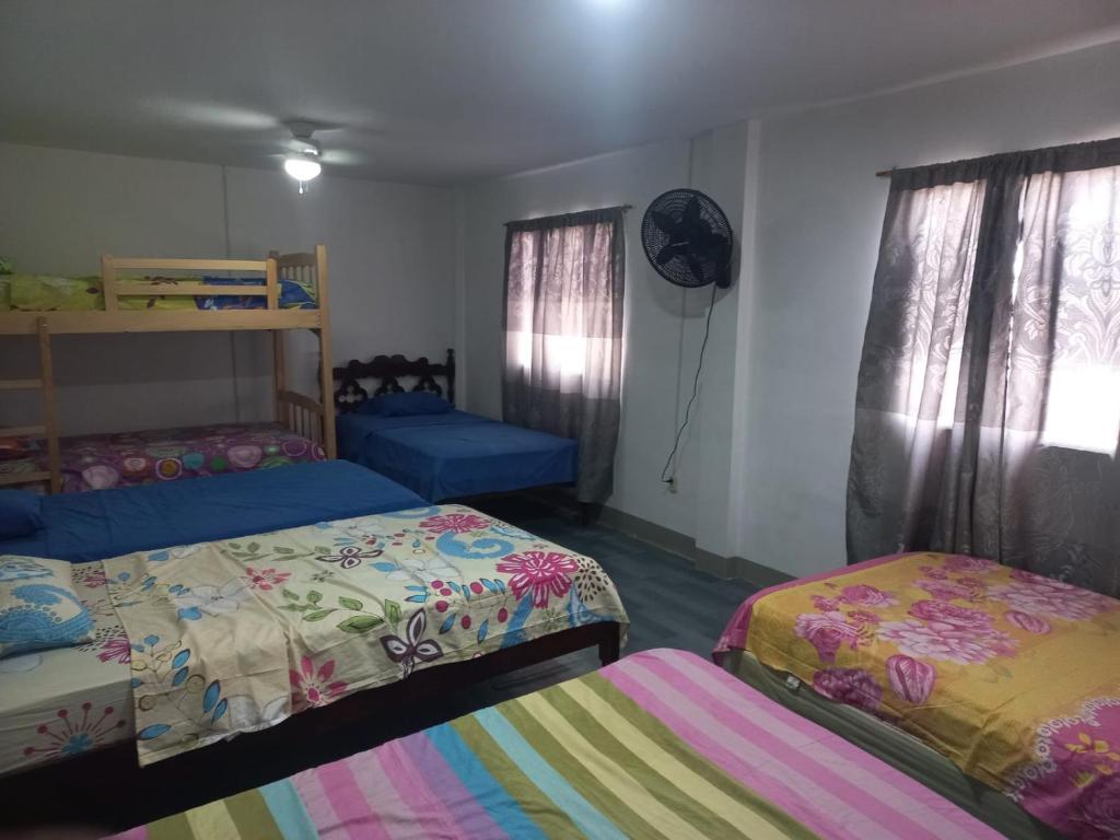 a bedroom with two beds and a fan at Habitaciones Grupales in Playas