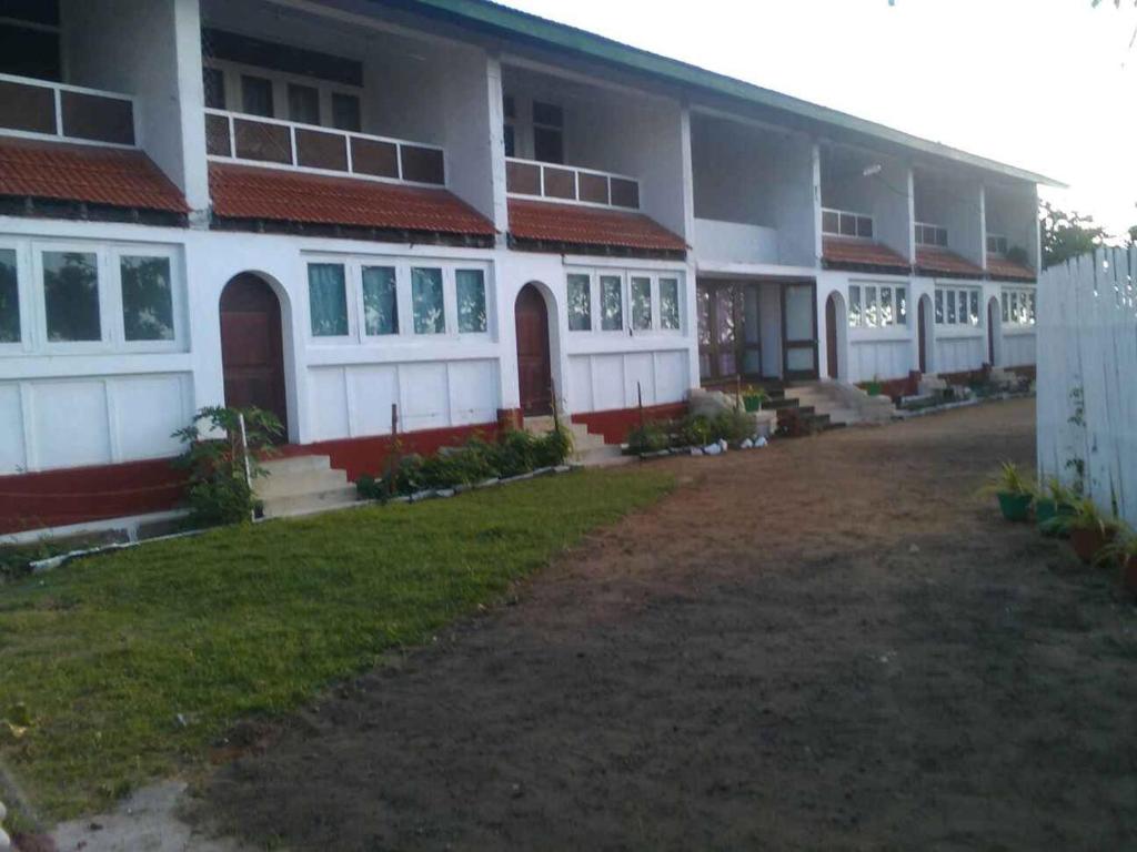 een groot wit gebouw met een tuin ervoor bij New Rest House Sea view Hotel in Negombo
