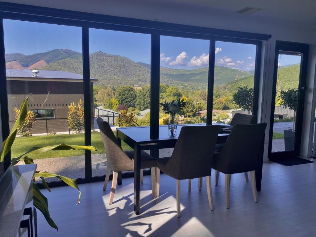 a dining room with a table and chairs and mountains at Altura Apartment Bright in Bright