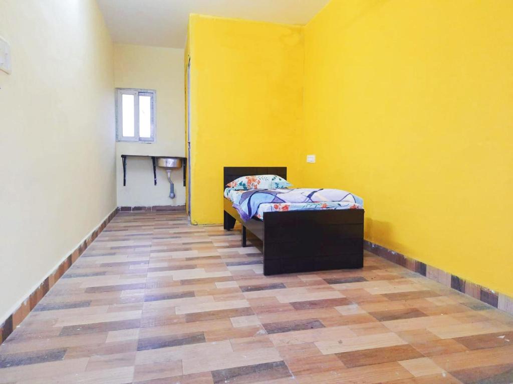 a bedroom with a bed and a yellow wall at Hi Bengaluru in Bangalore