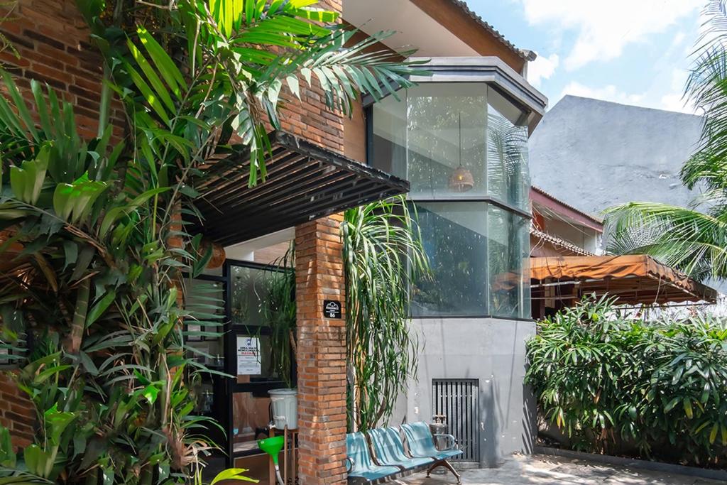 a brick building with glass windows and palm trees at TwoSpaces Living at Pakis Residence in Wonokitri 2