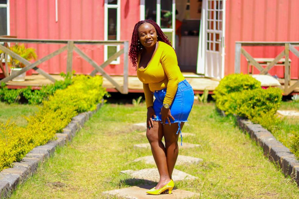 a woman standing on some steps in front of a house at The Red Container-Off Grid in Ngong