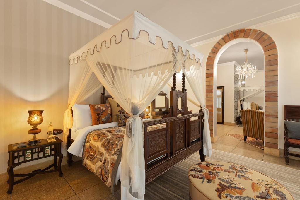 a bedroom with a bed with a canopy at Jaagir Manor, Dudhwa - IHCL SeleQtions in Paliā Kalān