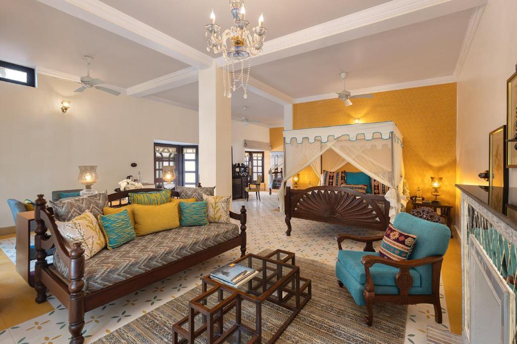 a living room with a couch and a chair at Jaagir Manor, Dudhwa - IHCL SeleQtions in Paliā Kalān