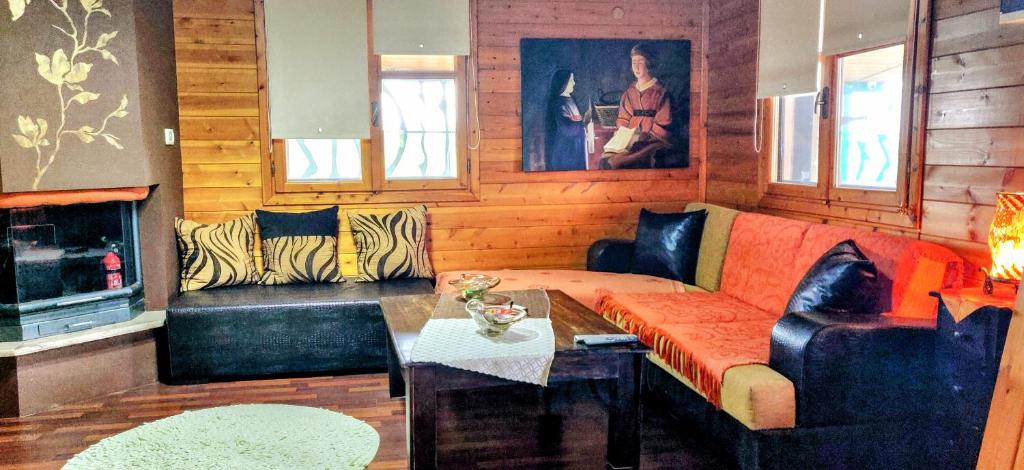 uma sala de estar com um sofá e uma mesa em Ikos Olympus - Elegant wooden cabin house near the beach em Paralia Katerinis