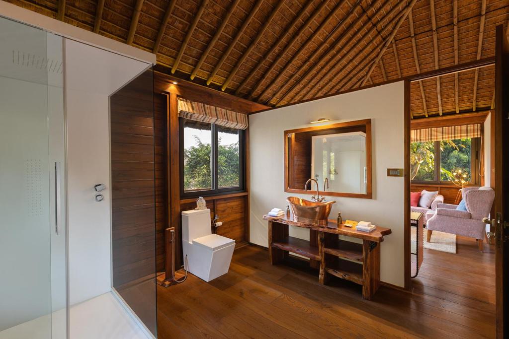 a bathroom with a toilet and a sink and a mirror at Jaagir Manor, Dudhwa - IHCL SeleQtions in Paliā Kalān