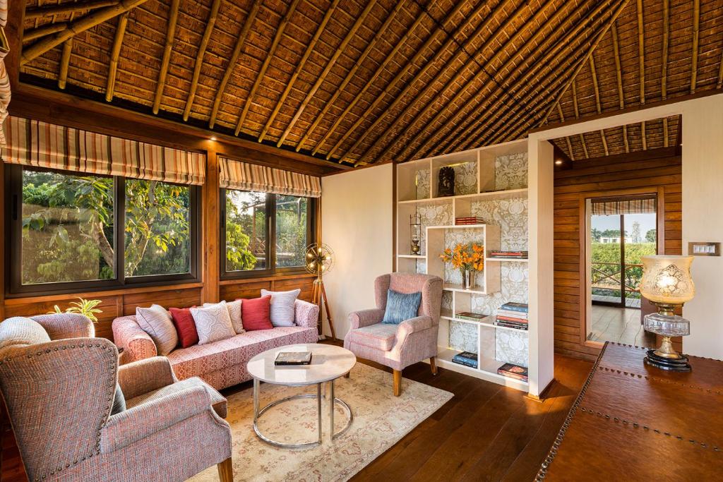 a living room with two couches and a table at Jaagir Manor, Dudhwa - IHCL SeleQtions in Paliā Kalān