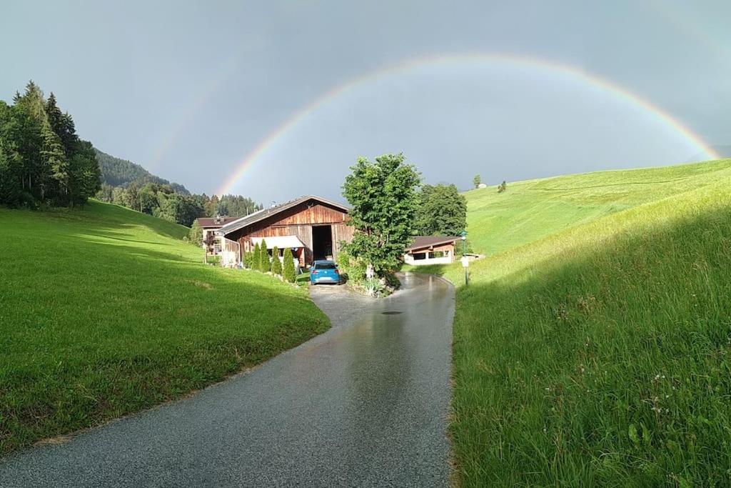 a rainbow over a road with a house and a car at Appartement Fischl in Jenbach