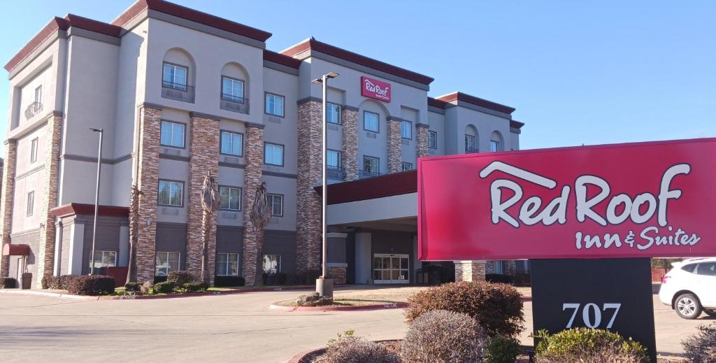 un panneau d'hôtel devant une auberge et des suites au toit rouge dans l'établissement Red Roof Inn & Suites Longview, à Longview