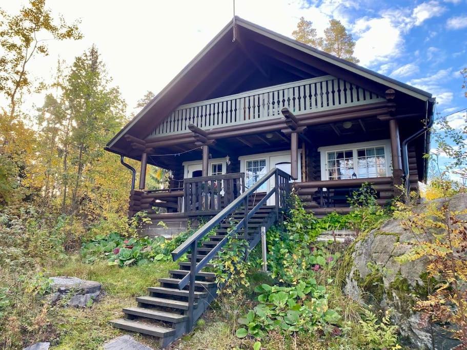 a log cabin with stairs leading up to it at Elämyksellinen huvila Tuurujärven rannalla. in Ulvila