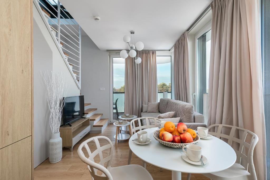 a living room with a table with fruit on it at Lighthouse Luxury Penthouse - Jantar Apartamenty in Mrzeżyno