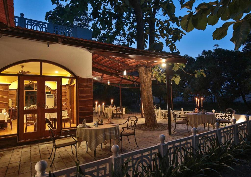 an outdoor dining area with tables and chairs at night at Jaagir Manor, Dudhwa - IHCL SeleQtions in Paliā Kalān