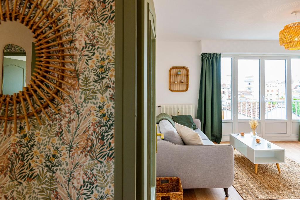 a living room with a couch and a mirror at Le Jouvence Cozy - Confort - Zen - Parking gratuit in Dijon