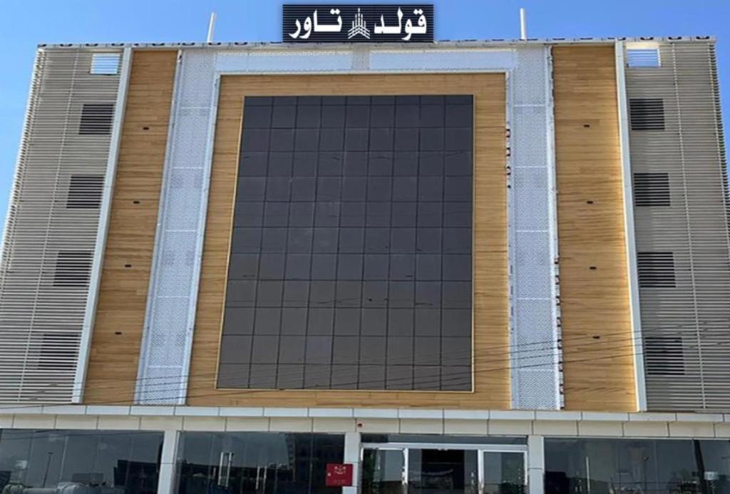 ein großes Gebäude mit einem Schild darüber in der Unterkunft قولد تاور in Chamis Muschait