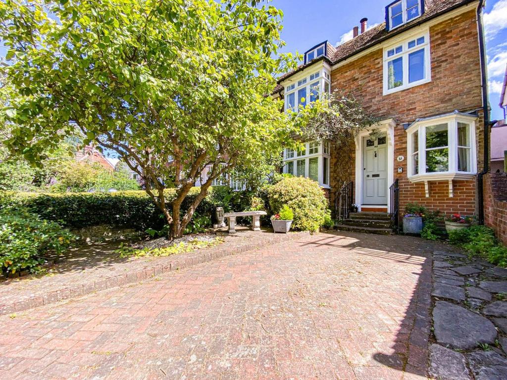 a brick house with a tree and a brick driveway at Quince Cottage in Saint Michaels