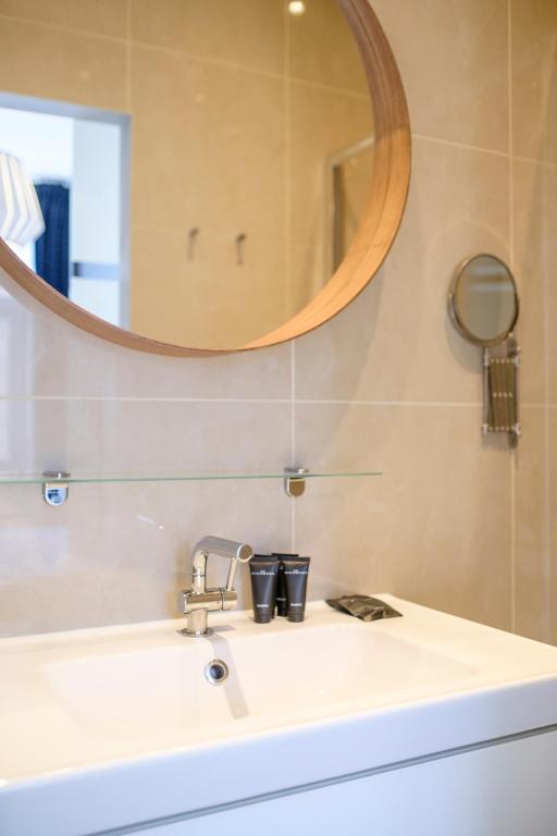 a bathroom with a sink and a mirror at Charmant Appartement 1 chambre avec balcon proximité Cinquantenaire in Brussels