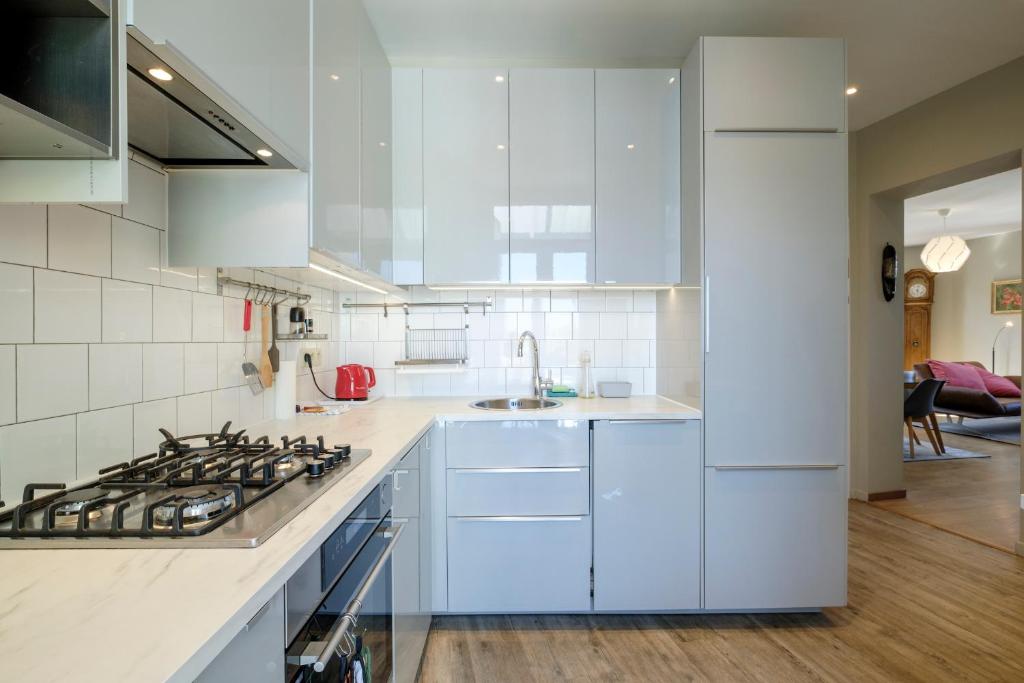 a kitchen with white cabinets and a stove top oven at Charmant Appartement 1 chambre avec balcon proximité Cinquantenaire in Brussels