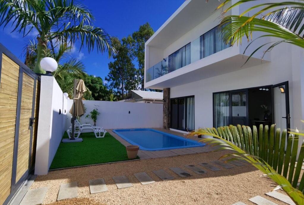 a house with a swimming pool in the yard at villa de la lumiere in Trou aux Biches