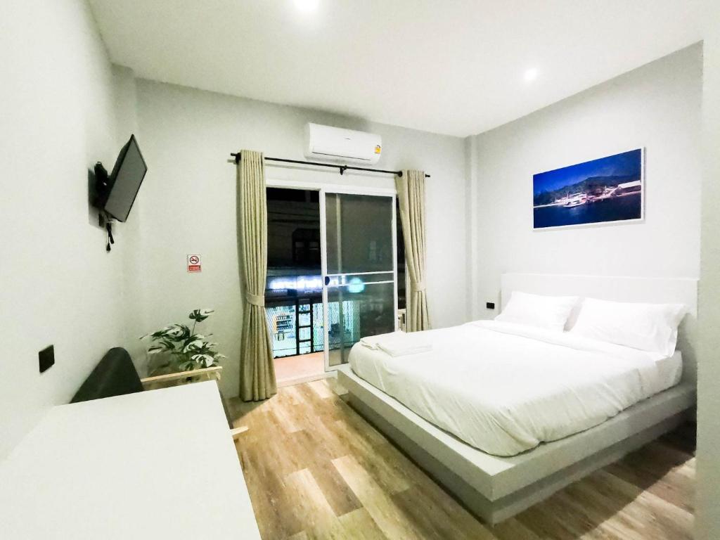 biała sypialnia z łóżkiem i oknem w obiekcie Port Station Koh Tao w Ko Tao