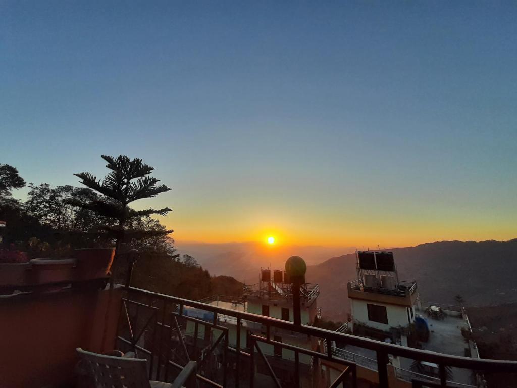 a view of the sun setting from a balcony at Hotel Sunrise View in Nagarkot
