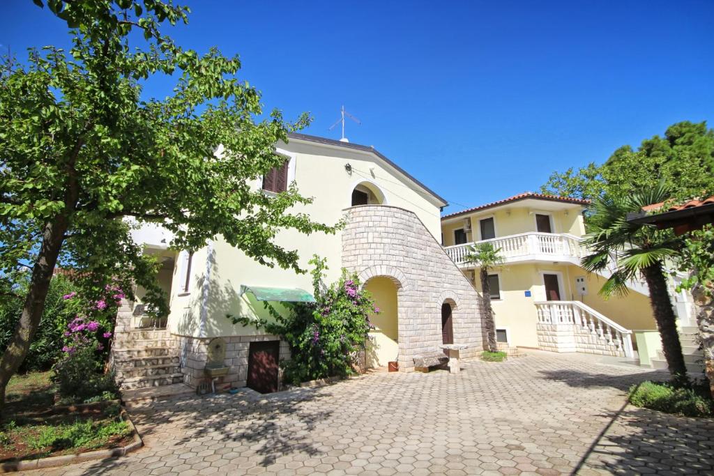 a large white house with a brick driveway at Barbic in Medulin