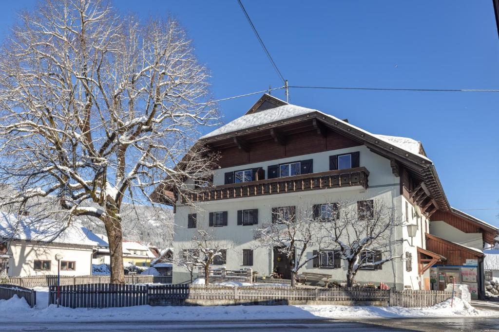 un gran edificio blanco con nieve en el techo en Bauernhof Oberlöffele, en Jenig