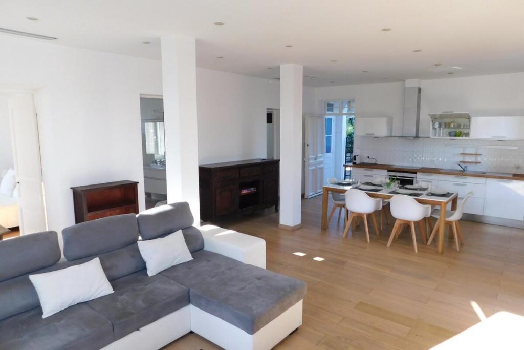 a large living room with a couch and a kitchen at "T3 ground floor of the villa "Les muguets" 3 minutes from the beach" in Vallauris