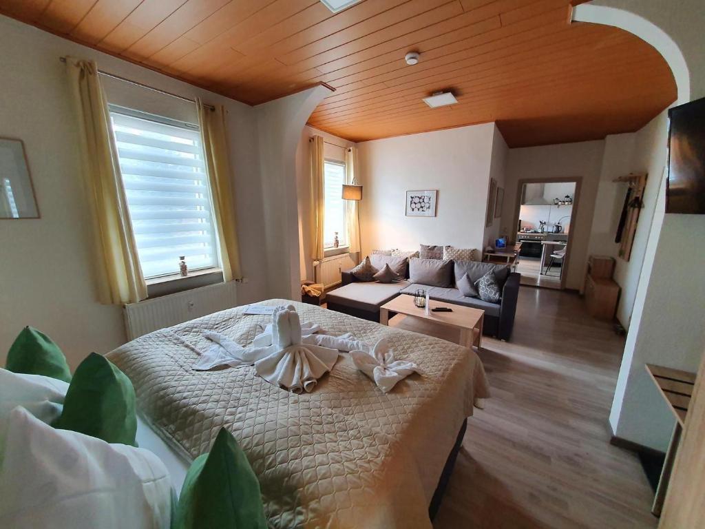 ein Schlafzimmer mit einem Bett und ein Wohnzimmer in der Unterkunft Wohlfuehl-Wohnung mit Sternekomfort und Balkon in Tanne in Tanne