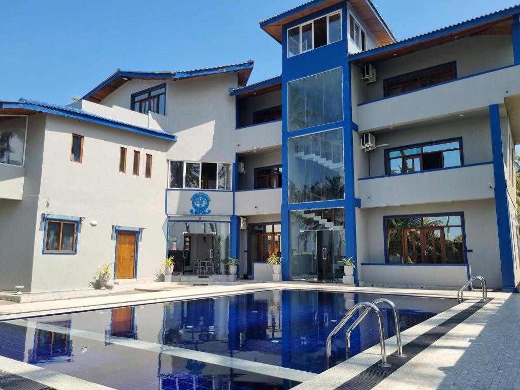 un edificio de apartamentos con piscina frente a él en Dhammika Beach Palace en Wadduwa